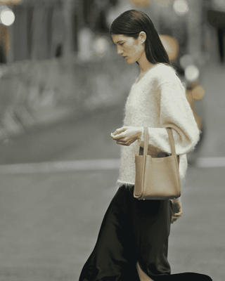 A model strolling with a Luna bag on her arm.