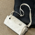 Mini Yore Camera Bag in cloud white vegetable-tanned leather with silver hardware and ebony wood zipper pull.