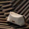 Songmont canvas storage bag with leather trim and logo, ideal for makeup and essentials.