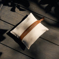 Songmont canvas tissue box cover with tan leather strap on wood, dappled sunlight.