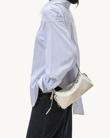 Mini Yore Camera Bag in cloud color made from vegetable-tanned leather with silver hardware.