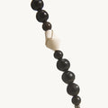 Large Carefree Thread Charm in Sandal color, featuring alternating dark wooden beads and a cream leather knot detail.