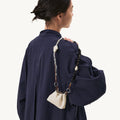 Large Carefree Thread Charm in Sandal color, featuring sandalwood and seed beads, with a cream leather pouch.