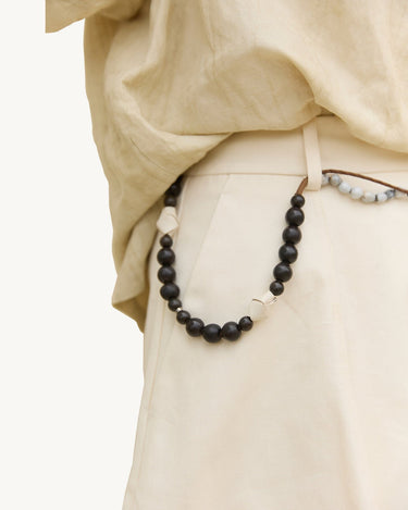 Large Carefree Thread Charm Sandal: dark beads, leather diamonds, seed beads on trousers.