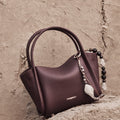 Small Carefree Thread Charm bag in plum, featuring pebbled leather, 'Songmont' logo, and beaded charm.