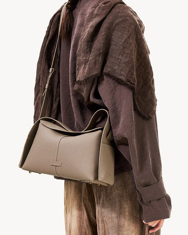Drippy Roof Bag in Cobble textured leather with adjustable strap, worn crossbody.