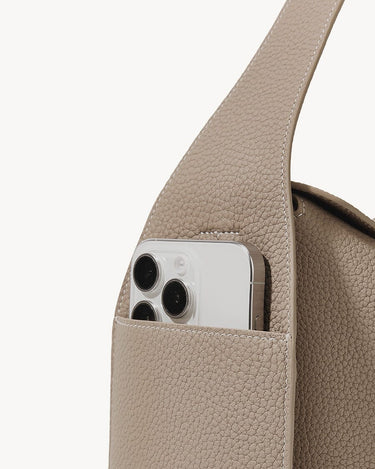 Drippy Roof Bag in Cobble leather, showing a phone pocket with a smartphone partially inserted.