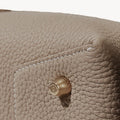 Drippy Roof Bag in Cobble taupe leather with brass hardware detail and visible stitching.