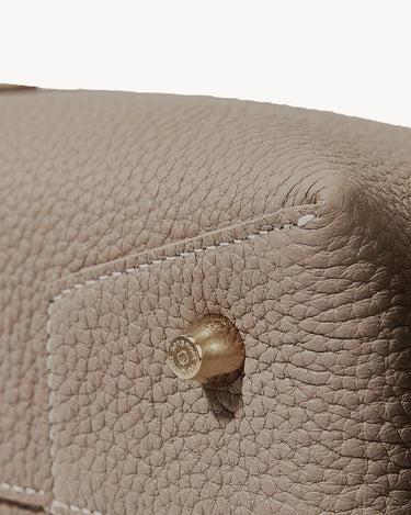 Drippy Roof Bag in Cobble taupe leather with brass hardware detail and visible stitching.