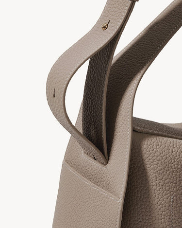 Drippy Roof Bag in Cobble: Textured taupe leather tote with detailed stitching and gold hardware accent.