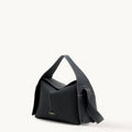 Black full-grain leather Drippy Roof Bag with flap closure and white stitching. Features gold "Songmont" logo.