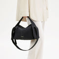 Black pebbled leather Drippy Roof Bag with white stitching, adjustable strap, and 'Songmont' logo