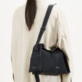 Black full-grain leather Drippy Roof Bag with white stitching and gold hardware, worn by a model.