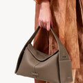 Taupe leather Drippy Roof Bag with pebbled texture and white stitching, a luxury shoulder bag.