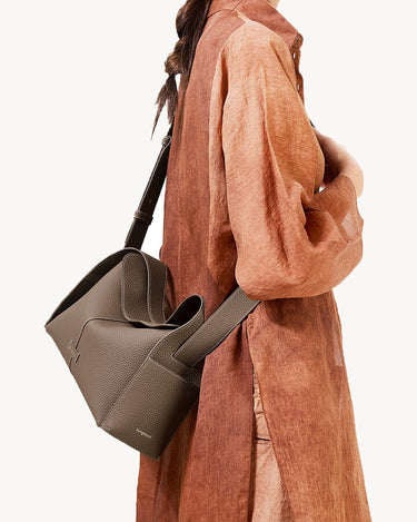 Taupe Drippy Roof Bag by Songmont, textured full-grain leather tote with architectural design. Adjustable strap for crossbody/shoulder wear.