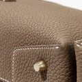 Taupe full-grain leather Drippy Roof Bag with contrast stitching and embossed Songmont brass hardware.