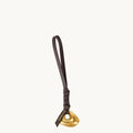 Faith Stone Charm accessory with golden abstract charm and dark leather strap, featuring 'Songmont' logo.