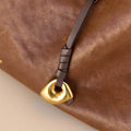 Faith Stone Charm bag accessory in brown leather with gold charm and leather tie