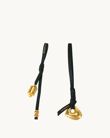 Faith Stone & Prayer Wheel Charm set: gold metal charms on black leather with 'Songmont' logo.