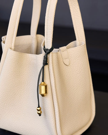 Faith Stone & Prayer Wheel Charm Set: Sandal textured leather tote with gold hardware charm detail.
