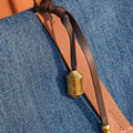 Faith Stone Charm & Prayer Wheel Charm Set in Sandal color with brass prayer wheel charm and leather strap.