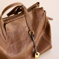 Faith Stone Charm & Prayer Wheel Charm Set in Sandal color, vegetable-tanned leather with gold hardware.