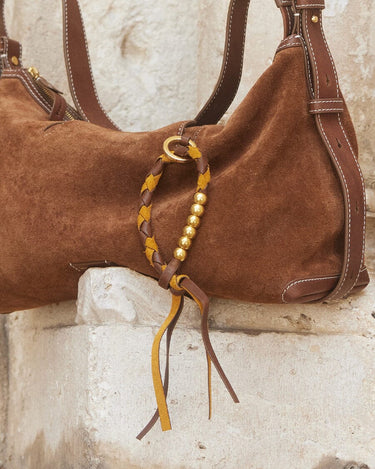 Brown suede Freedom Cord bag with braided leather detail and gold beads.