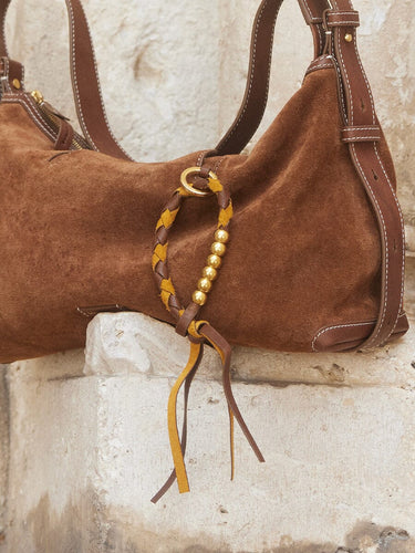 Brown suede Freedom Cord bag with braided leather detail and gold beads.