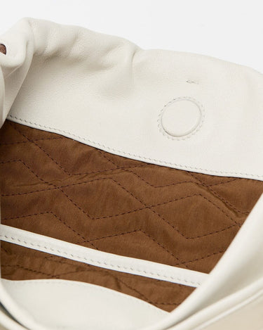 Interior of white Gather Clutch Set with quilted brown lining and magnetic snap closure.