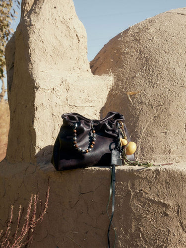 Ebony Gather Clutch Set in full-grain nappa leather with beaded strap and gourd charm.