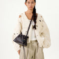 Ebony Gather Clutch Set on model wearing distressed knit cardigan and beige trousers