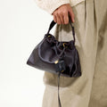 Ebony Gather Clutch Set in full-grain nappa leather with braided handle and gold hardware.