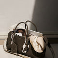 Large Yore Bowling Bag in Moss green full-grain leather with laptop, scarf, and phone inside.