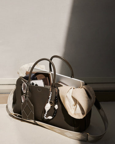 Large Yore Bowling Bag in Moss green full-grain leather with laptop, scarf, and phone inside.