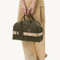 Large Yore bowling bag in moss green pebbled leather with a cream and beige diamond-patterned strap.