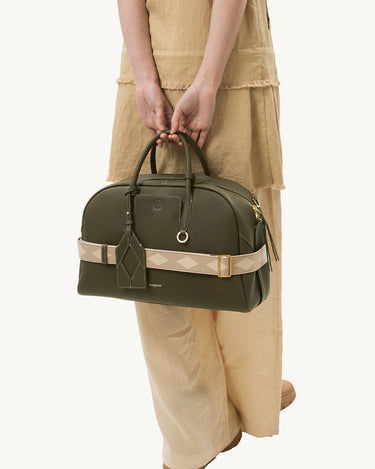Large Yore bowling bag in moss green pebbled leather with a cream and beige diamond-patterned strap.