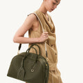 Large Yore Bowling Bag in moss green pebbled leather with white stitching and gold hardware.
