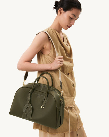 Large Yore Bowling Bag in moss green pebbled leather with white stitching and gold hardware.