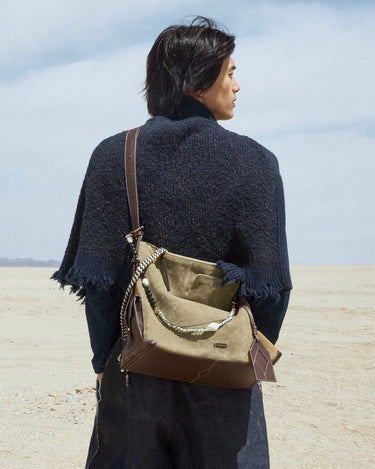 Large Yore Hobo Bag in Dune Suede with leather accents, worn by a person against a desert backdrop.