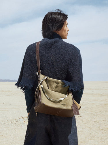 Large Yore Hobo Bag in Dune Suede with leather accents, worn by a person against a desert backdrop.