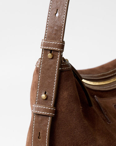 Large Yore Hobo Bag in Sandal Suede. Detailed view of the adjustable strap with white stitching and metal hardware.