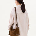 Large Yore Hobo Bag in Sandal Suede, made of cow suede leather and vegetable-tanned leather, worn by a model.