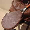 Brown leather tennis racket cover with 'Songmont' embossed, alongside a matching leather bag and tennis racket.