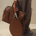 Limited edition brown leather tennis racket cover with embossed 'Songmont' logo, paired with a matching duffel bag.