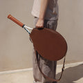 Brown vegetable-tanned leather tennis racket cover with embossed "Songmont" logo, holding a tennis racket.