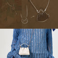 White full-grain nappa leather Lucky Pouch Charm with drawstring closure, worn by a model.