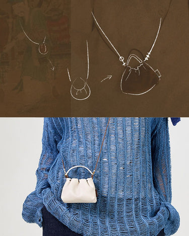 White full-grain nappa leather Lucky Pouch Charm with drawstring closure, worn by a model.