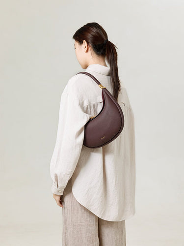 Burgundy Luna Bag, pebble-grain leather crossbody bag with adjustable strap.