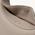 Close-up of the textured leather Luna Bag in Cobble color, showing the magnetic closure detail.