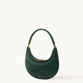 Emerald green Luna Bag in textured full-grain leather with gold hardware, showcasing a curved silhouette and elegant design.